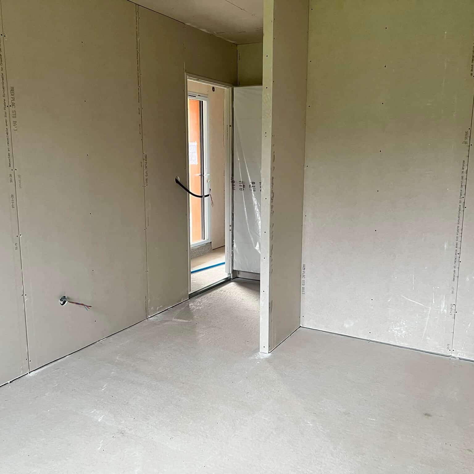 Cloisons intérieures en plaques de plâtre Frem Plac STD BA13, datées 27-11-22. Travaux de second œuvre, sol en ciment et passage de porte.